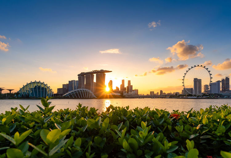 View of city buildings against cloudy sky at sunset