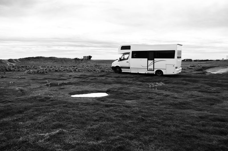 Camping van on landscape against sky
