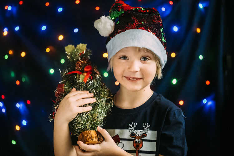 Portrait of smiling boy with illuminated christmas tree