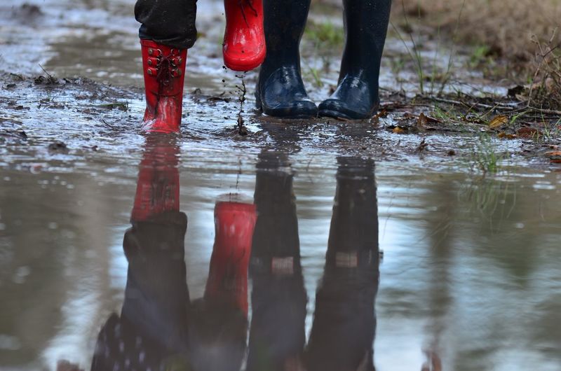 Low section of people standing in puddle