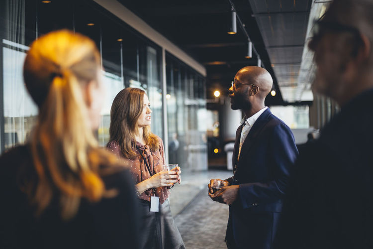 Female and male colleagues standing in corridor at workplace