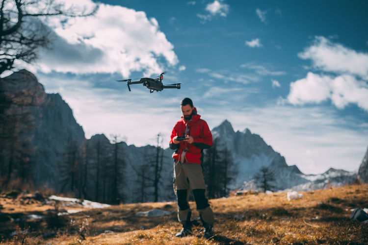 Man flying drone against mountains
