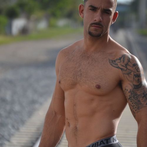 Portrait of shirtless handsome young man standing outdoors