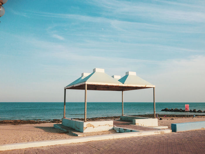 Lifeguard hut on beach against sky