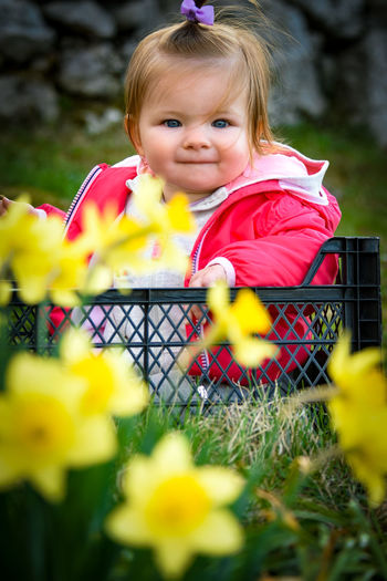 Portrait of cute baby girl sitting outdoors