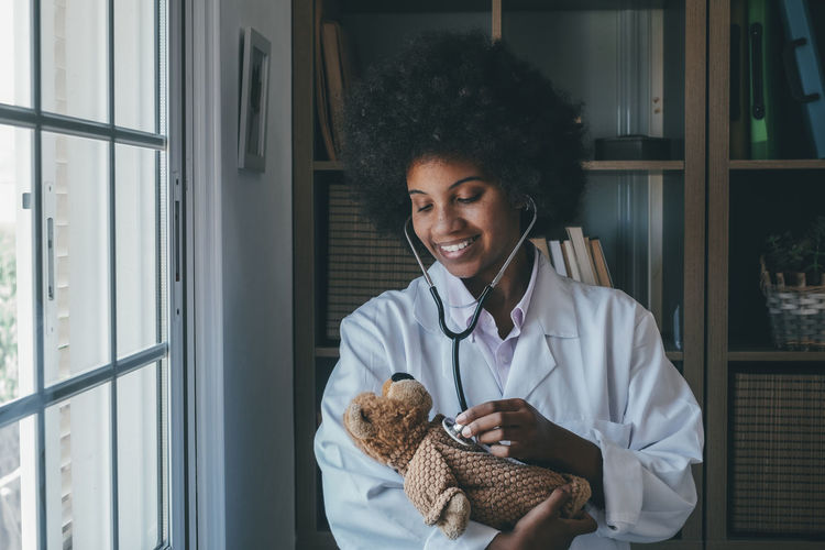 Doctor examining teddy bear at clinic