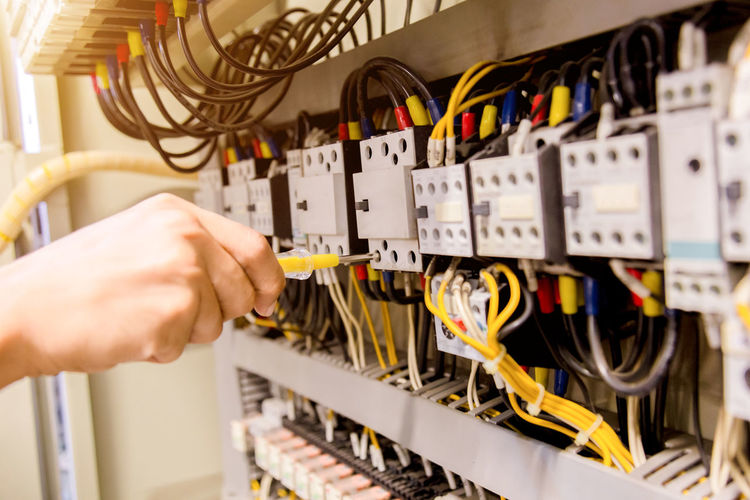 Cropped hands of electrician repairing electrical equipment