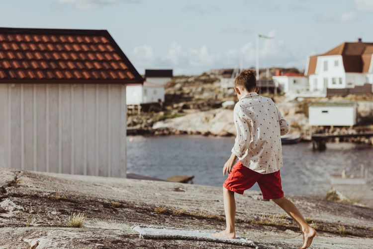 Boy walking over blanket on archipelago during sunny day