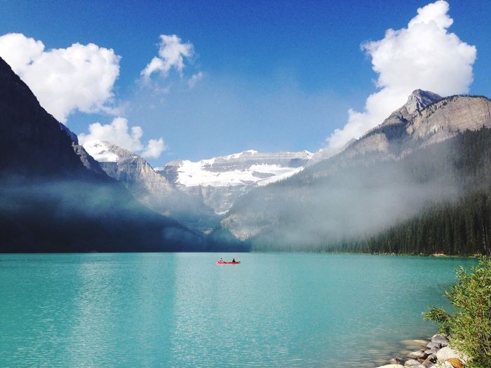 Scenic view of lake louise by mountains against sky