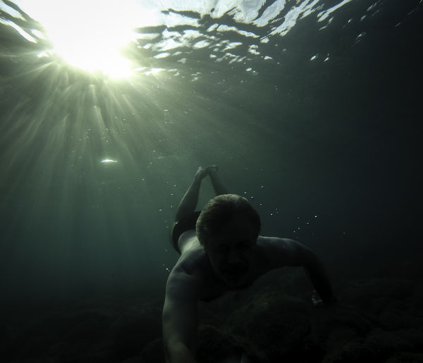 Full length of shirtless boy swimming in sea