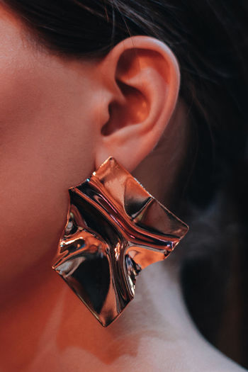 Golden interesting creative earring in a woman's ear. fashion modern accessories