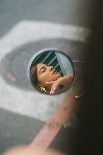Reflection of woman on side-view mirror