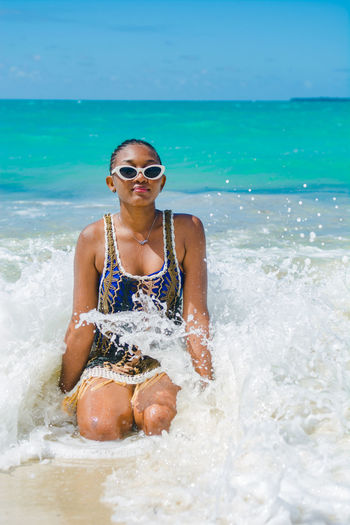 Portrait of a female young adult at the beach wearing sunglasses 