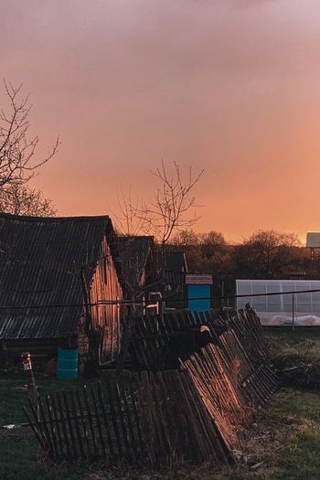 Houses and trees against sky during sunset
