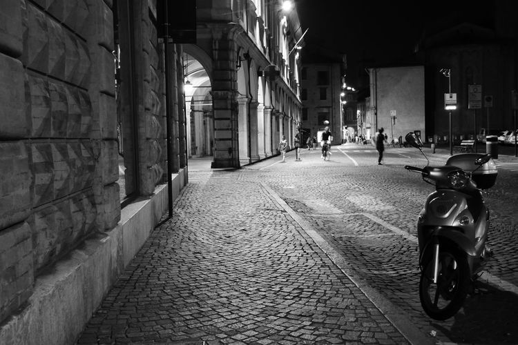 Man on walkway by street in city at night