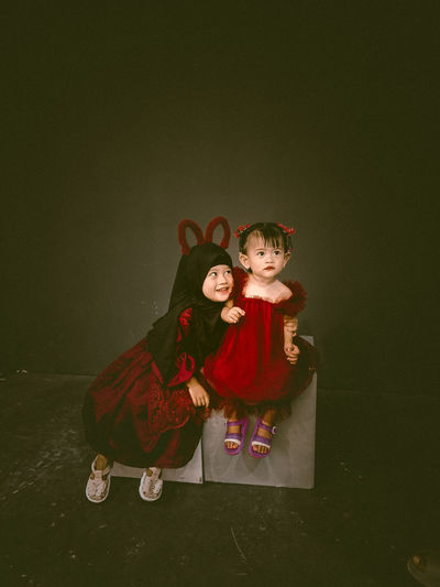 Two beautiful little girls wearing maroon dresses