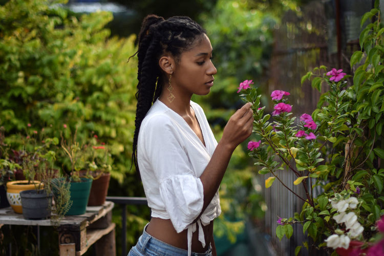 Young black woman smelling flowers