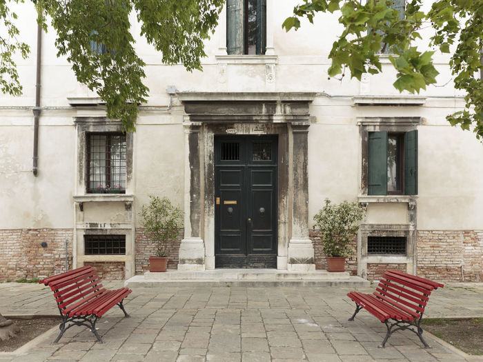 Empty chairs and tables against building