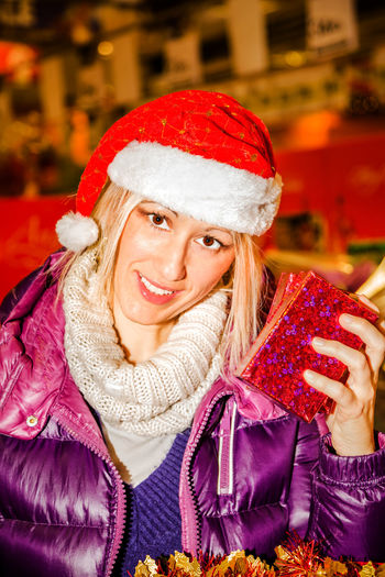 Portrait of smiling mature woman wearing santa hat during christmas