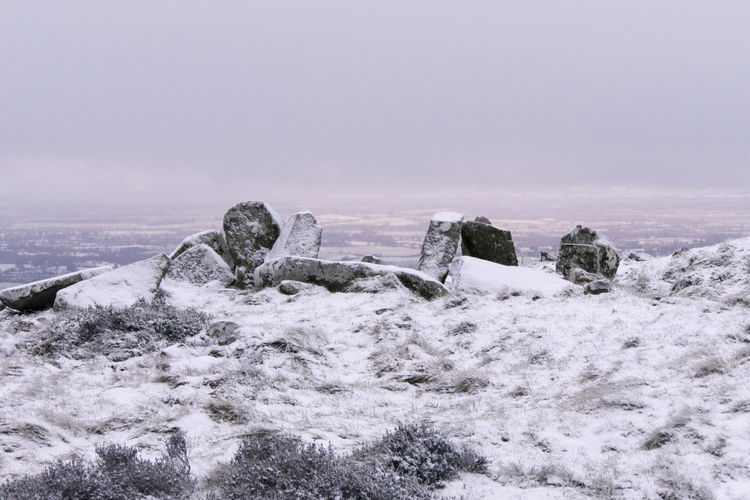 Standing stones of a neolithic portal tomb at a hilltop burial site in winter
