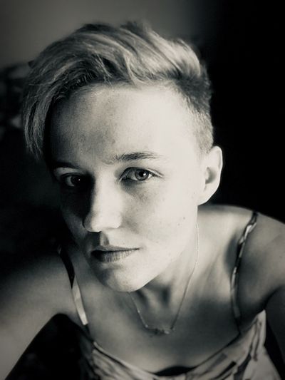 High angle portrait of young woman with short hair sitting at home