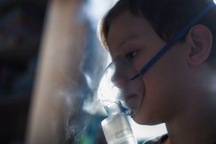 Close-up of boy wearing oxygen mask