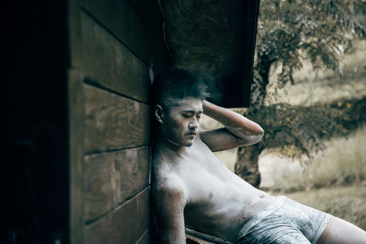 Young man with body paint relaxing outdoors