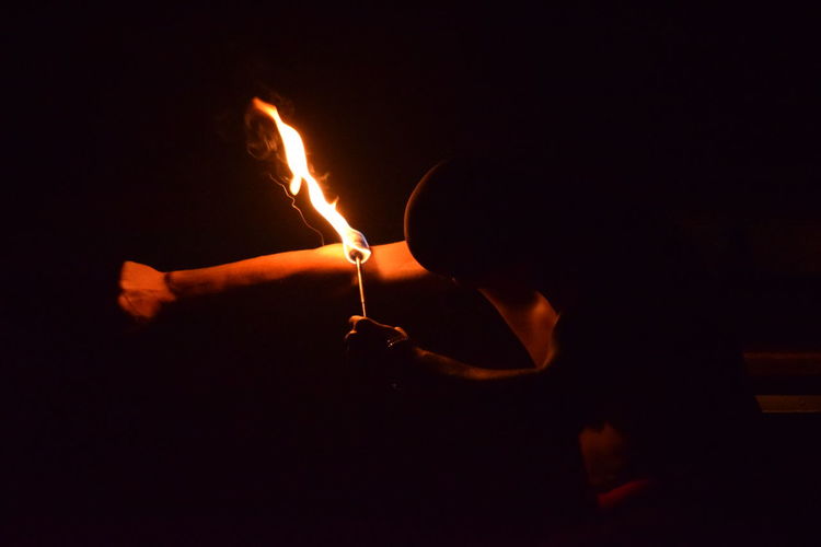 Close-up of burning candle in the dark