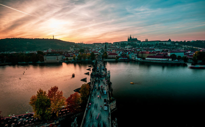 Panoramic view of river and buildings against sky at sunset