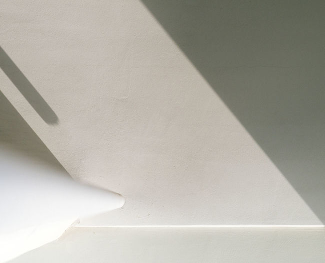 High angle view of white shadow on wall