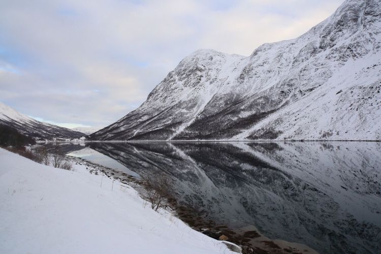 Scenic view of lake by snow against sky