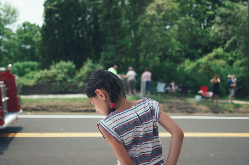Rear view of girl standing on road