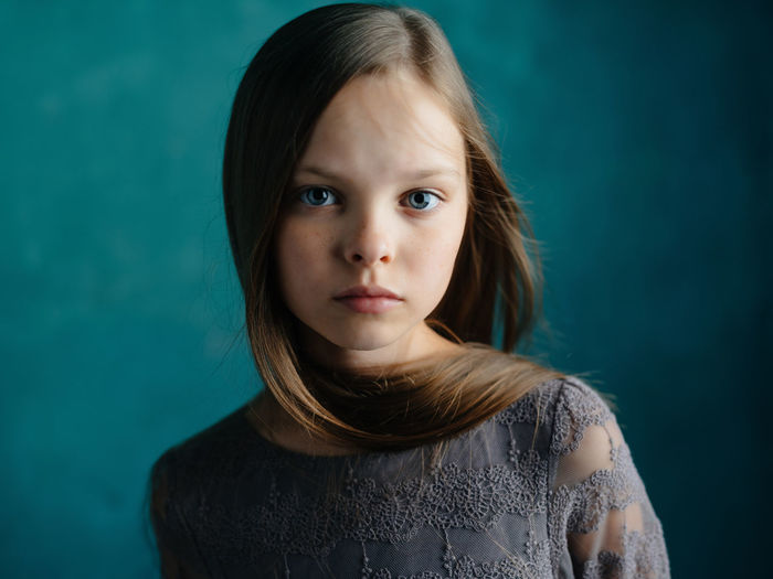 Portrait of girl against blue background