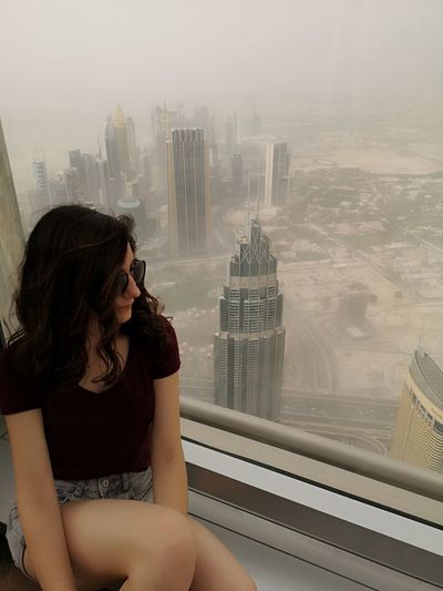 High angle view of woman looking at city through window
