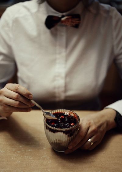 Midsection of woman with dessert in bowl on table
