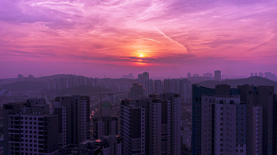Aerial view of buildings against sky during sunset