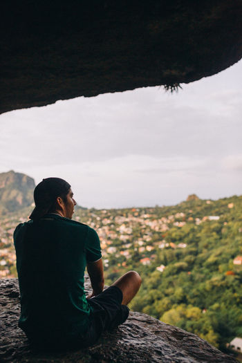 Man sitting on rock looking at view