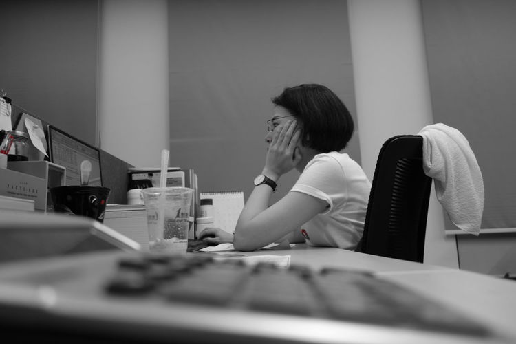 Close-up of calculator against woman working on desk