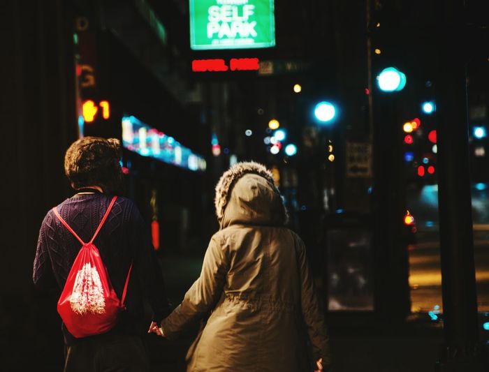 Woman in illuminated city at night