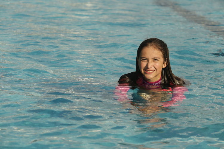 Portrait of happy girl in swimming pool