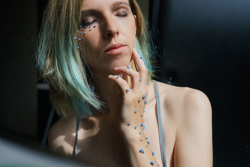 Close-up of woman with blue confetti on body
