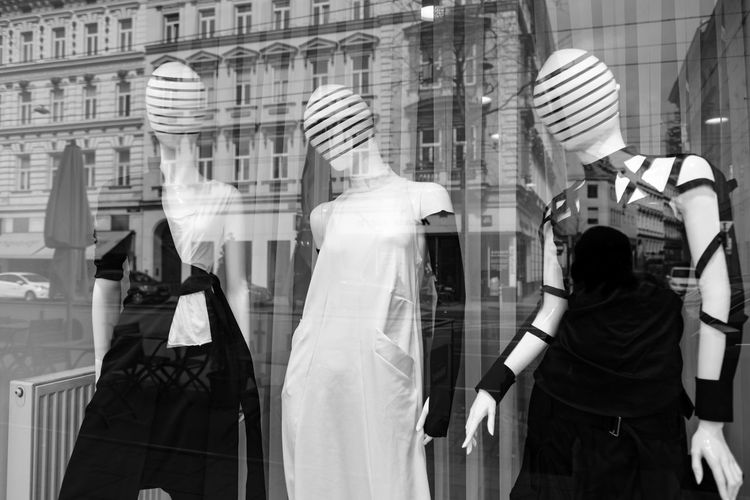 Mannequins in a display window with city reflections in black and white, vienna, austria.