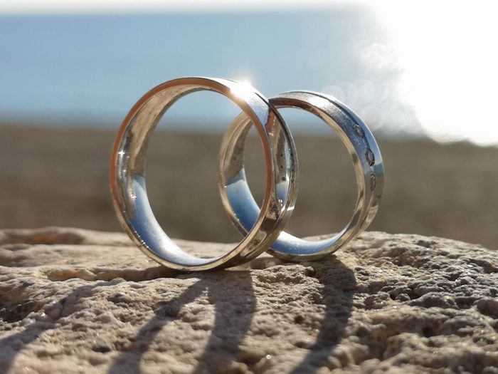 Close-up of wedding rings on sand