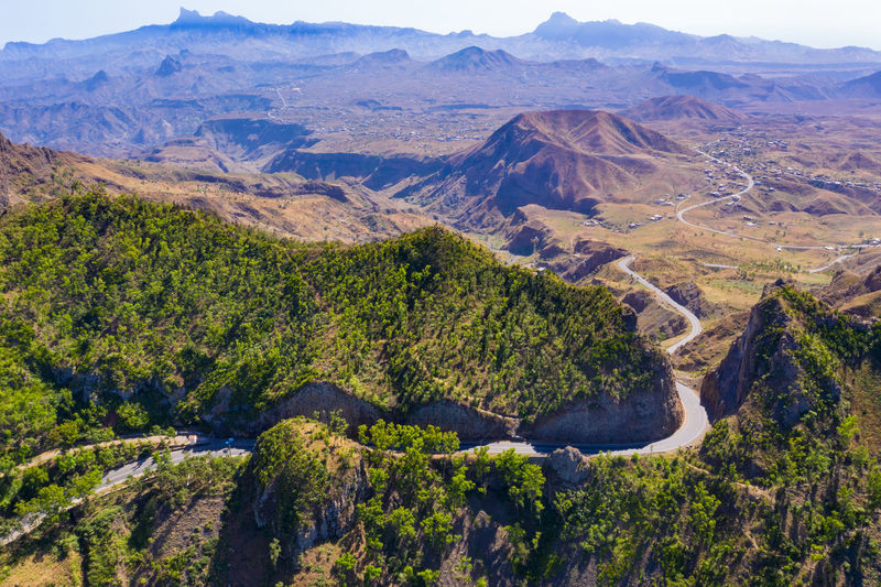 Aerial view of road amidst trees and mountains