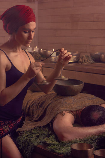 A woman performs a tibetan ritual with sound bells. the concept of therapy