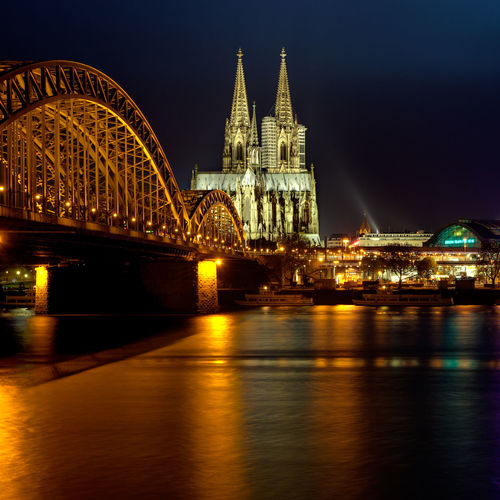 Hohenzollern bridge over rhine river in illuminated city at night