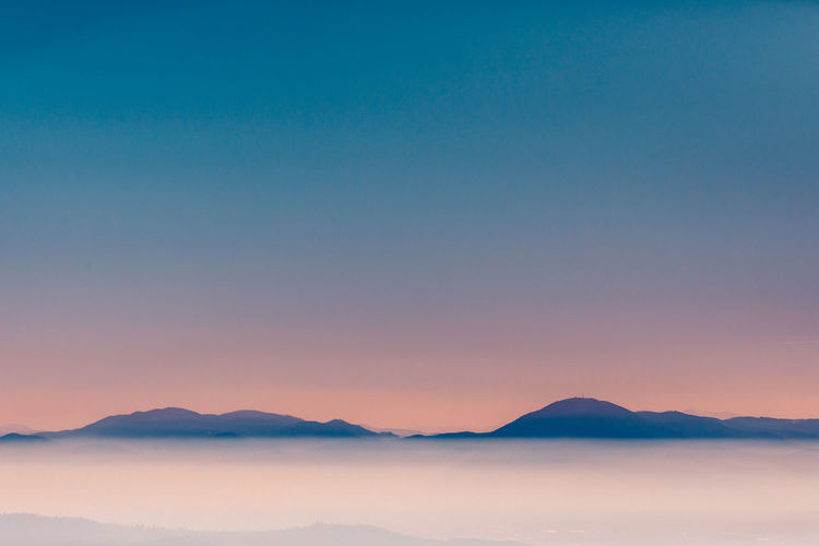 Scenic view of mountains against clear sky at sunset