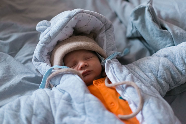 Sleeping newborn baby in warm winter clothes