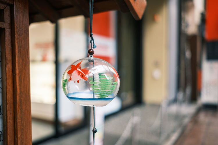 Close-up of wind bell hanging on glass building