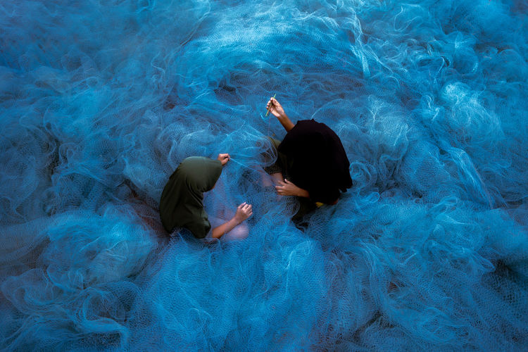 High angle view of two muslim making the blue trawl 